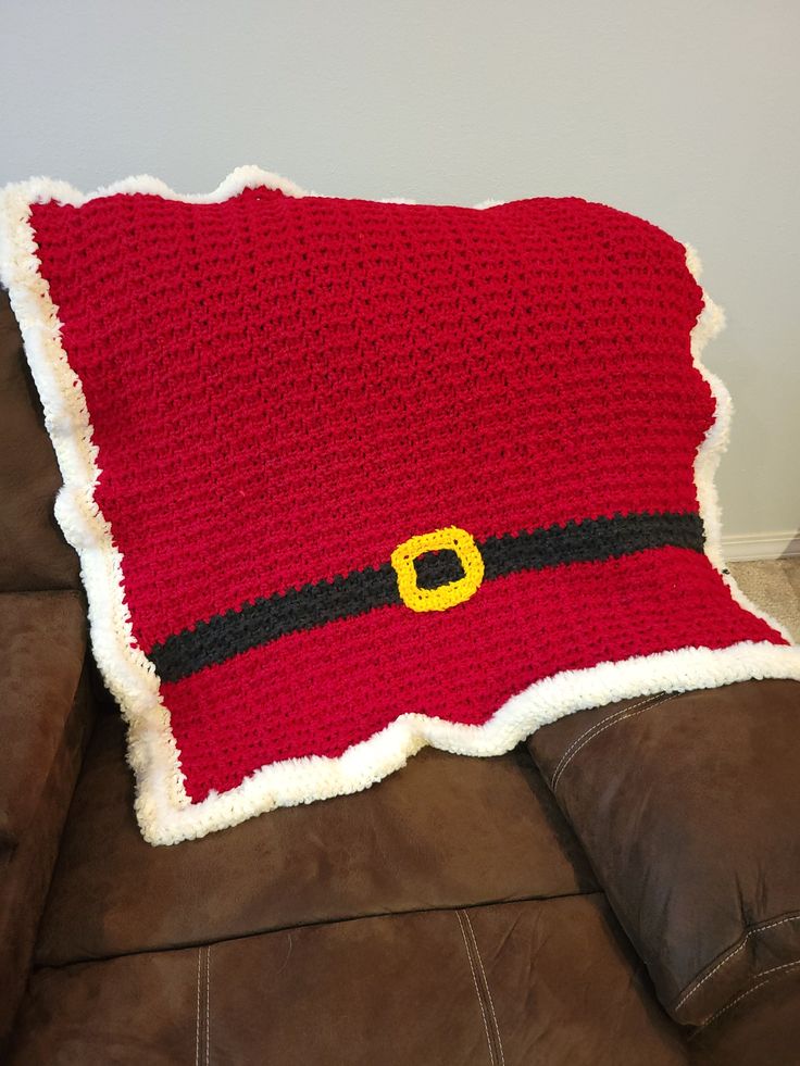 a crocheted santa claus pillow sitting on top of a couch