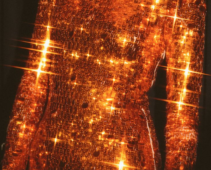 an image of a woman's body made out of orange and yellow lights in the dark