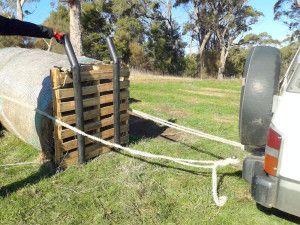 a truck pulling a large wooden crate on top of it's back end in the grass