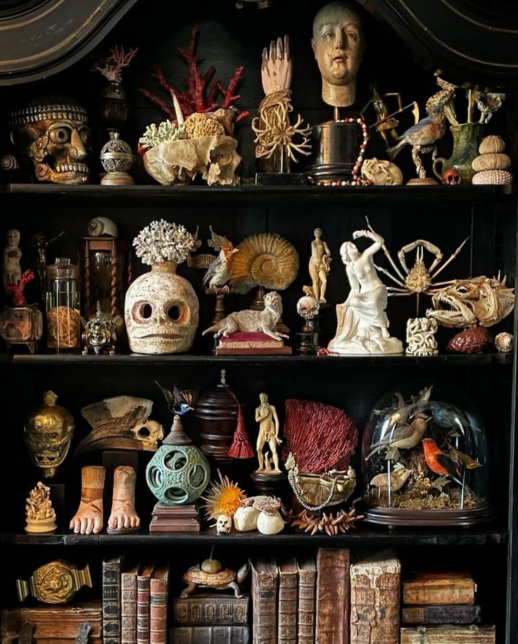 a bookshelf filled with lots of different types of figurines and sculptures