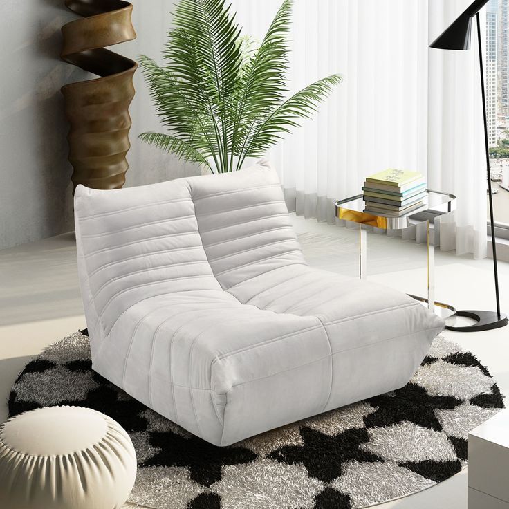 a white couch sitting on top of a black and white rug