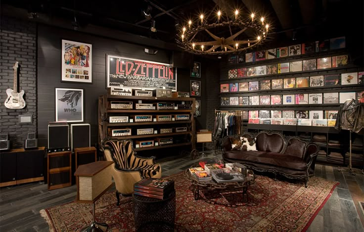 a living room filled with furniture and bookshelves covered in lots of different types of music memorabilia