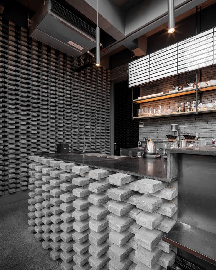 an industrial style bar with stacks of concrete blocks on the counter and shelves behind it