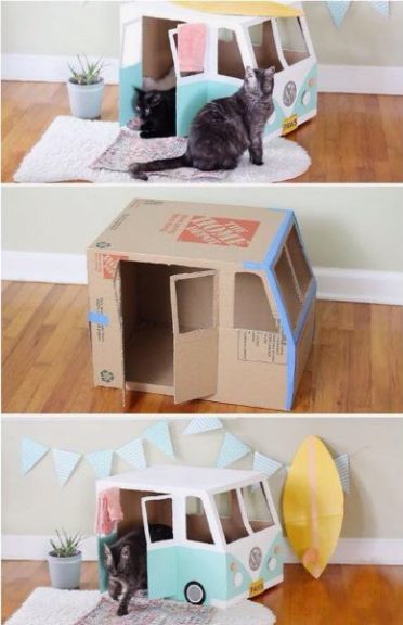 the cat is sitting in the cardboard house