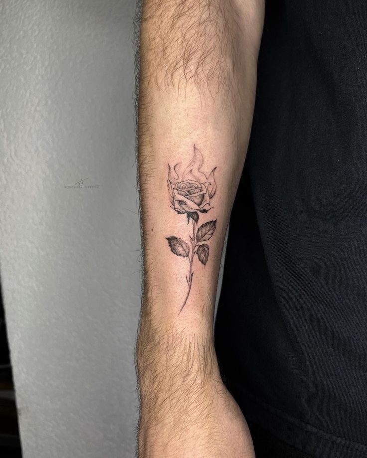 a man's arm with a rose tattoo on the left side of his arm