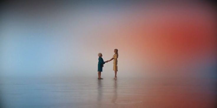 two children holding hands in the middle of a foggy area with red and blue colors