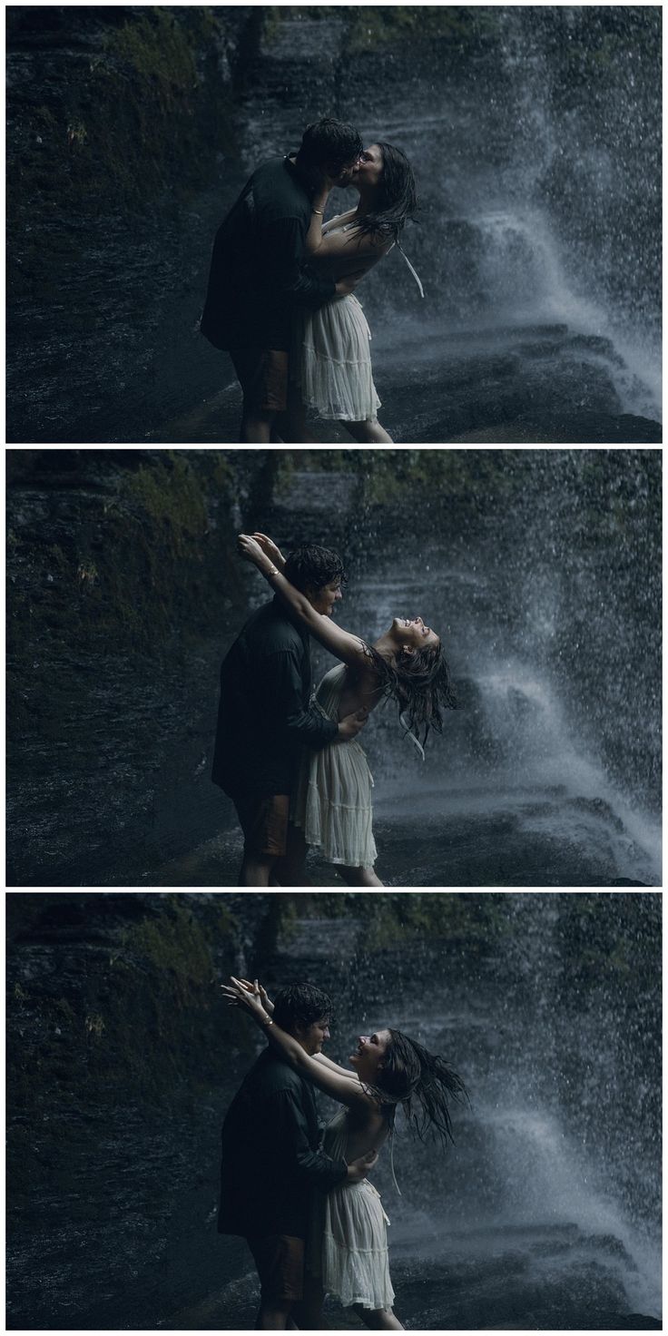 two people standing in front of a waterfall with their arms around each other and kissing