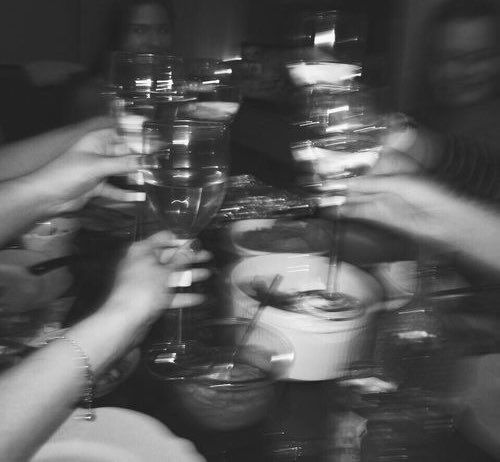 black and white photograph of people holding wine glasses