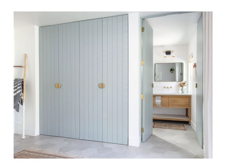 an open door leading to a bathroom with a sink and mirror on the other side