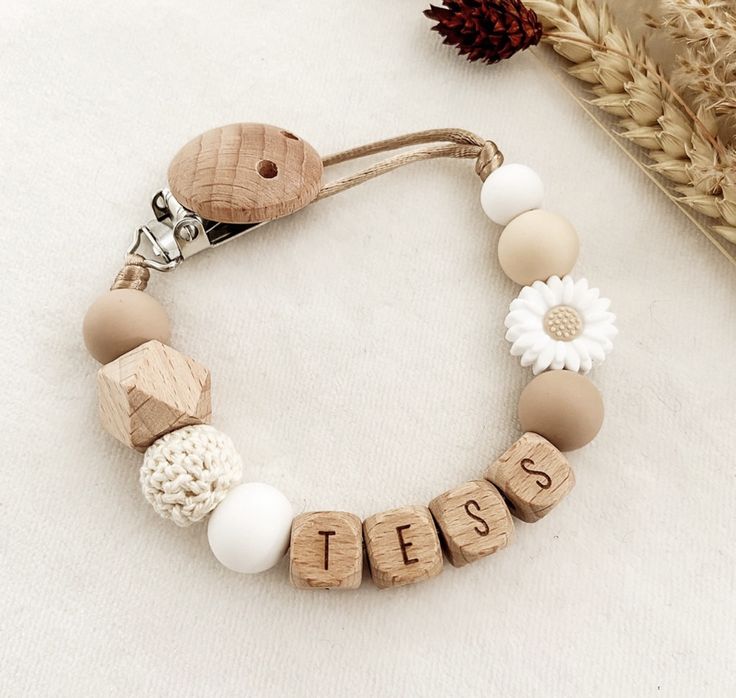 a wooden beaded name bracelet with white and beige beads