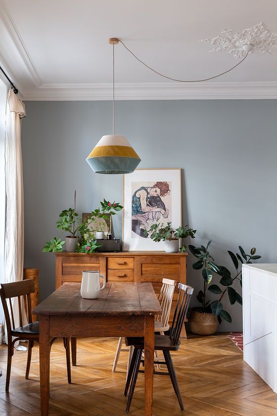 a dining room with blue walls and wooden furniture