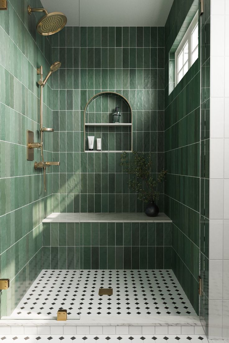 a green tiled bathroom with gold fixtures and black and white floor tiles on the walls