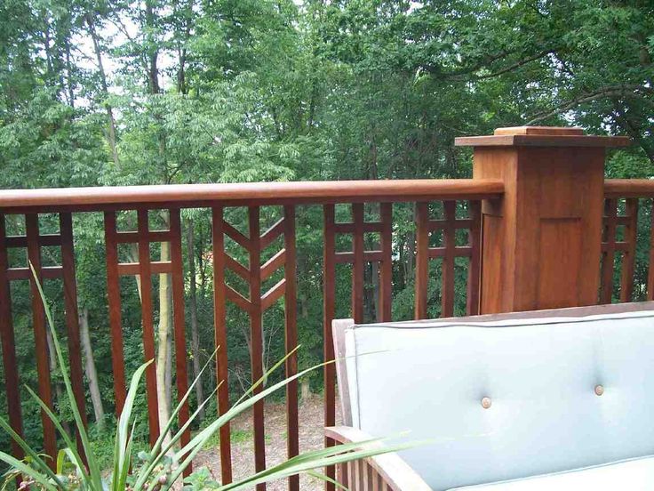 a white couch sitting on top of a wooden deck next to a tall green plant