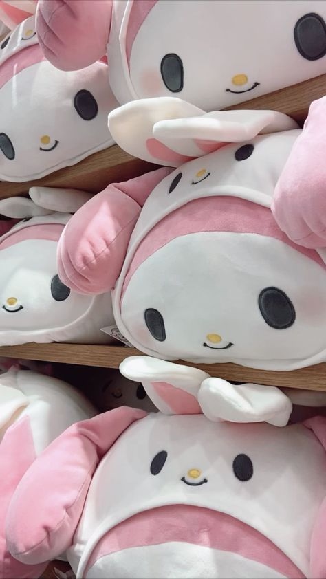 many pink and white stuffed animals stacked on top of each other