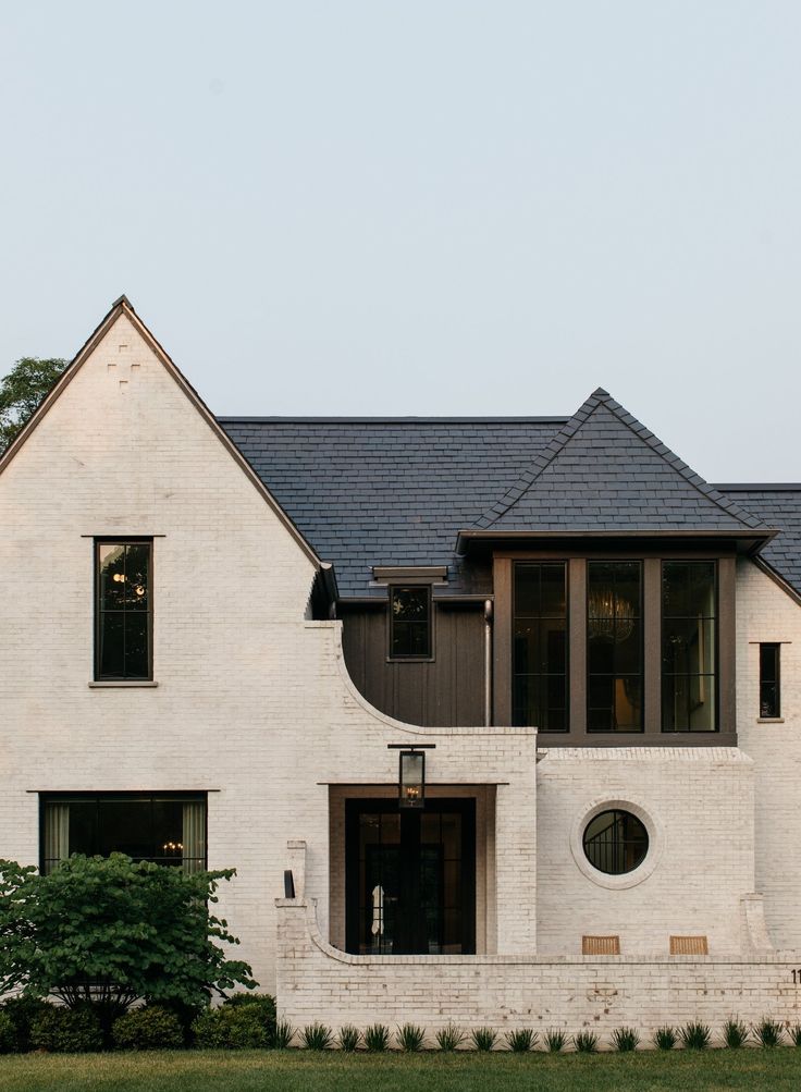 a large white brick house with two story windows