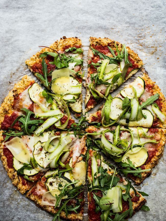 a pizza topped with zucchini, cheese and other toppings