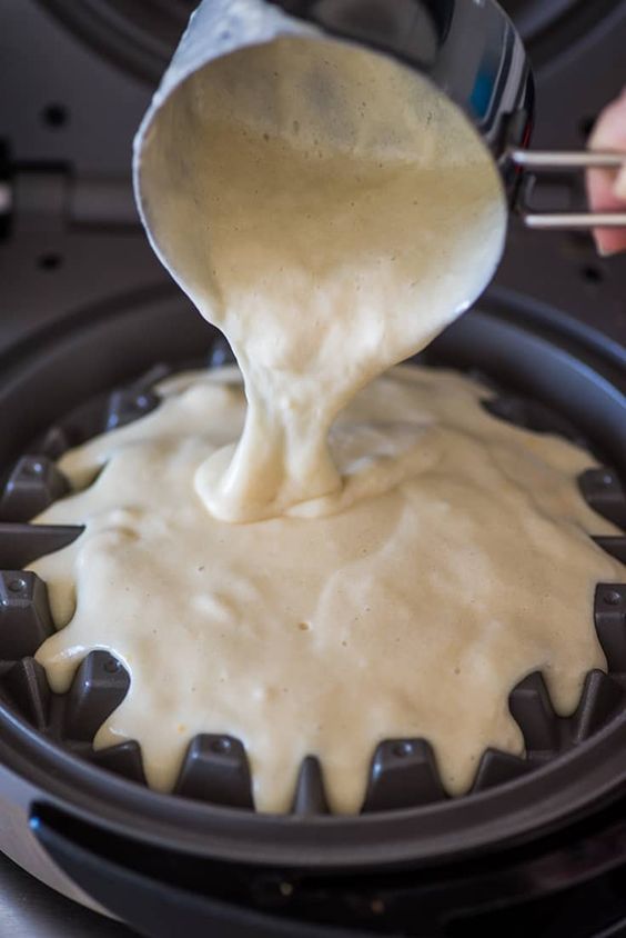 a person pouring batter on top of a cake