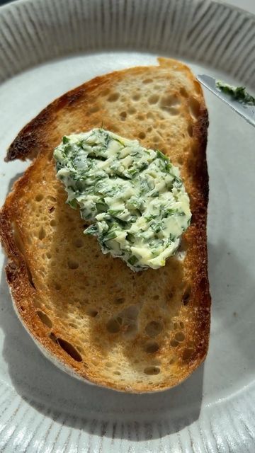 a piece of bread on a paper plate topped with cream cheese and spinach spread