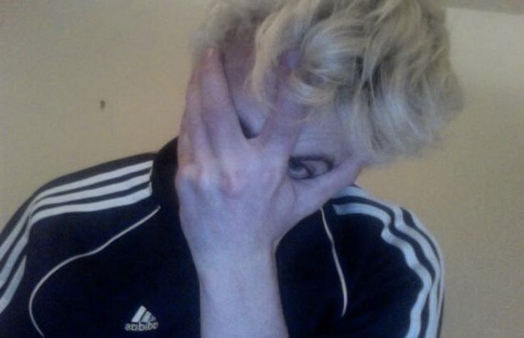 a woman with blonde hair covering her face