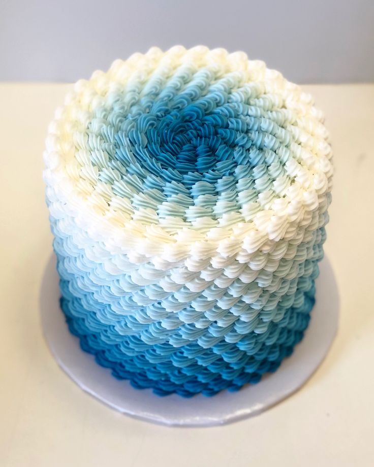 a blue and white cake sitting on top of a table