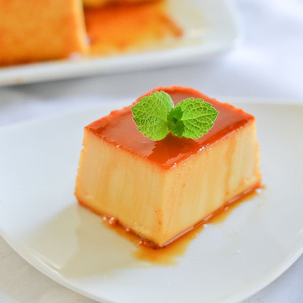 a small piece of cake on a plate with a mint garnish in the center