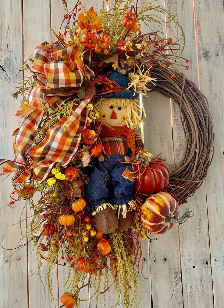 a scarecrow wreath with pumpkins and gourds