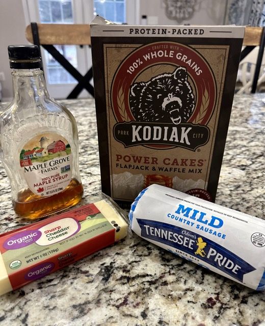 ingredients to make homemade cheesecakes laid out on a counter top next to a bottle of kodiak