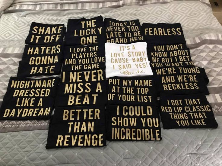 four black and white towels with words on them sitting on top of a bed in a room