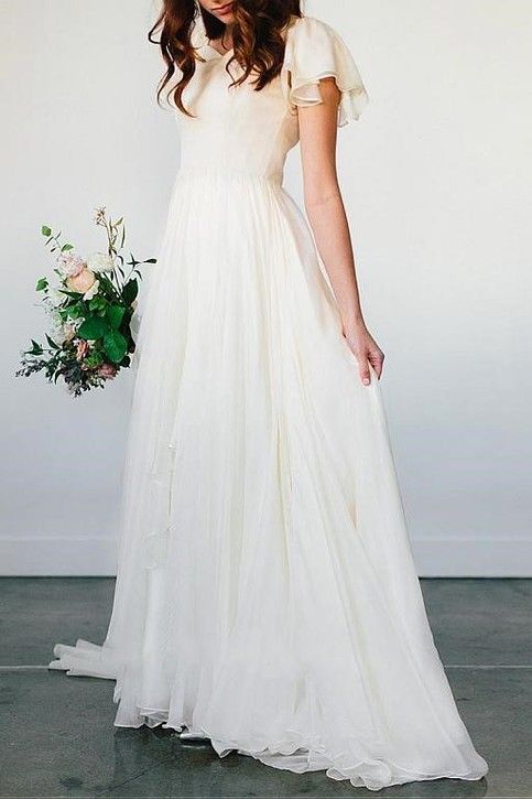 a woman in a white dress holding a bouquet