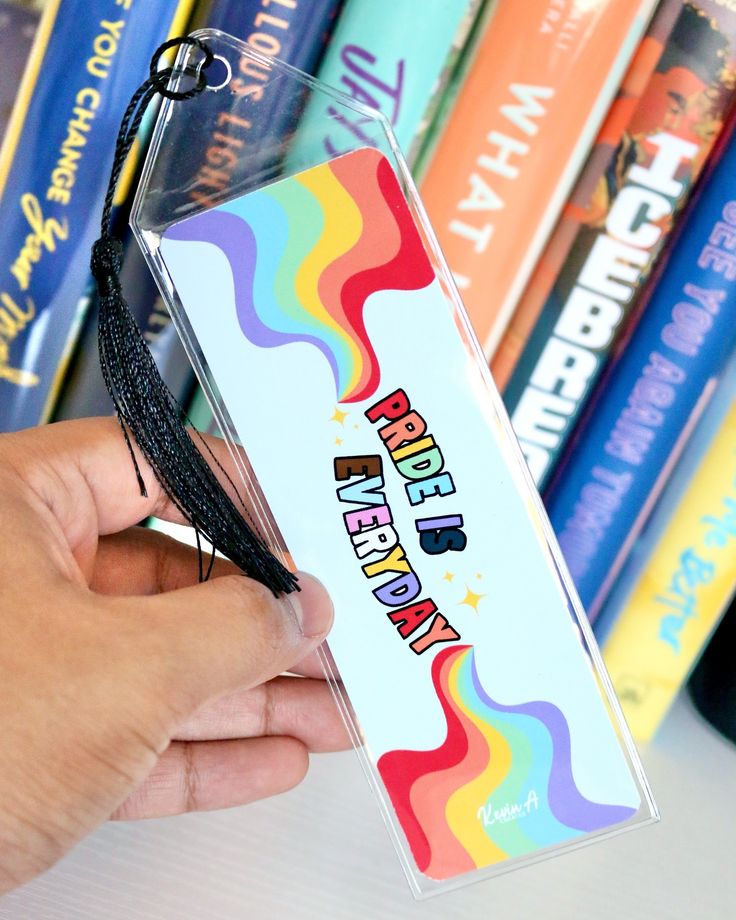 a person is holding a bookmark in front of some books