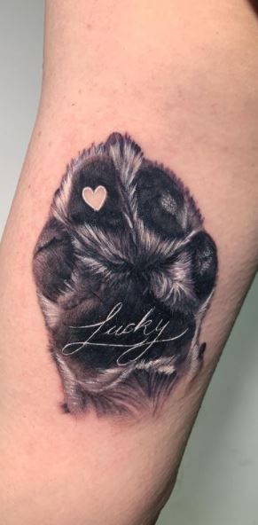 a black and white photo of a dog's paw with the word love written on it