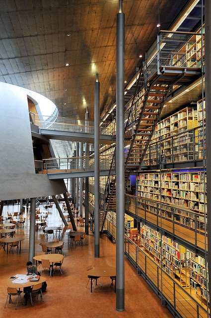 the interior of a library filled with lots of book shelves and tables covered in books