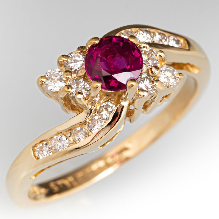 a gold ring with a pink stone surrounded by white diamonds