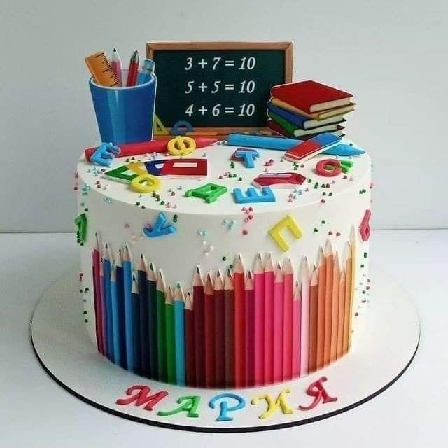 a multicolored birthday cake decorated with school supplies