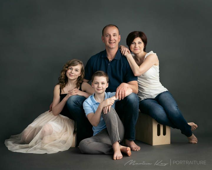 a family posing for a photo in front of a gray background