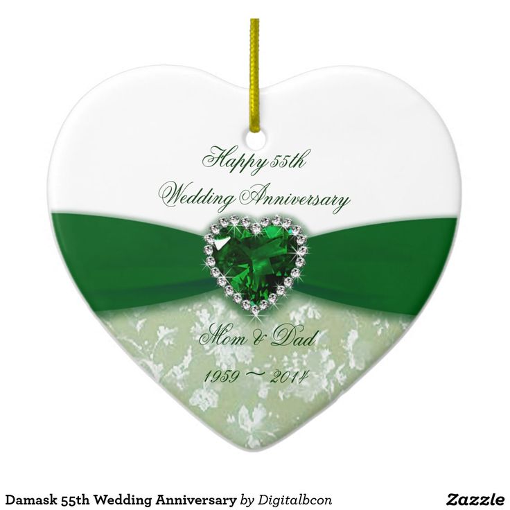 a heart shaped ornament with a green and white ribbon on it's side