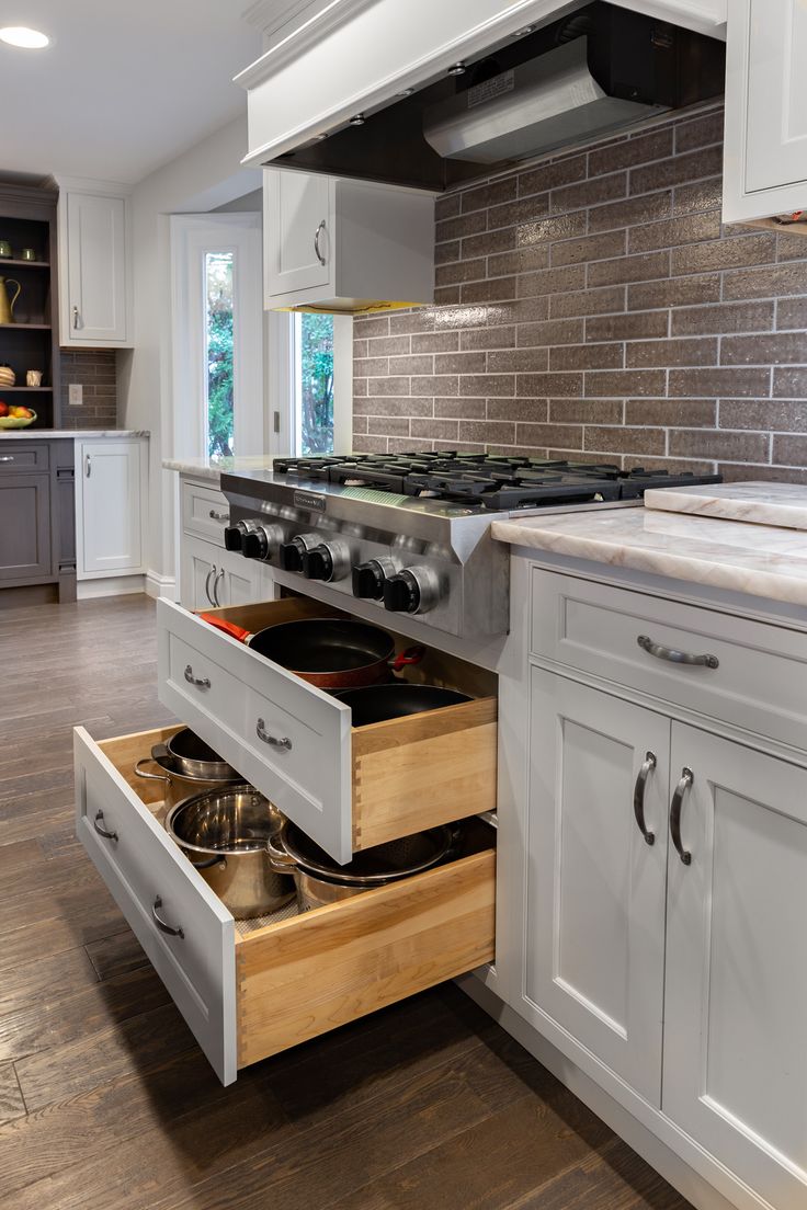 an open drawer in the middle of a kitchen