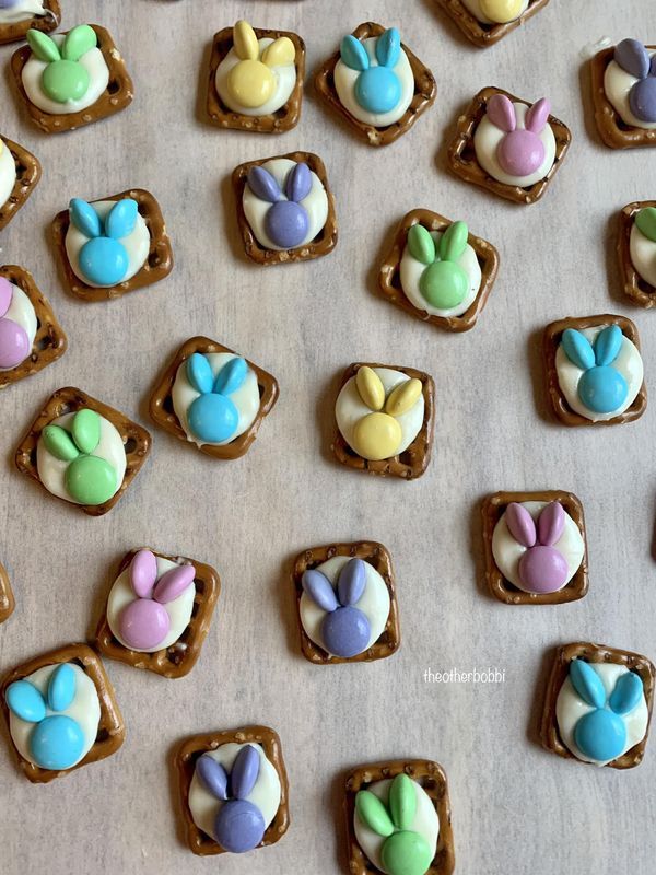 there are many small cookies on the table together with bunny ears and eggs in them