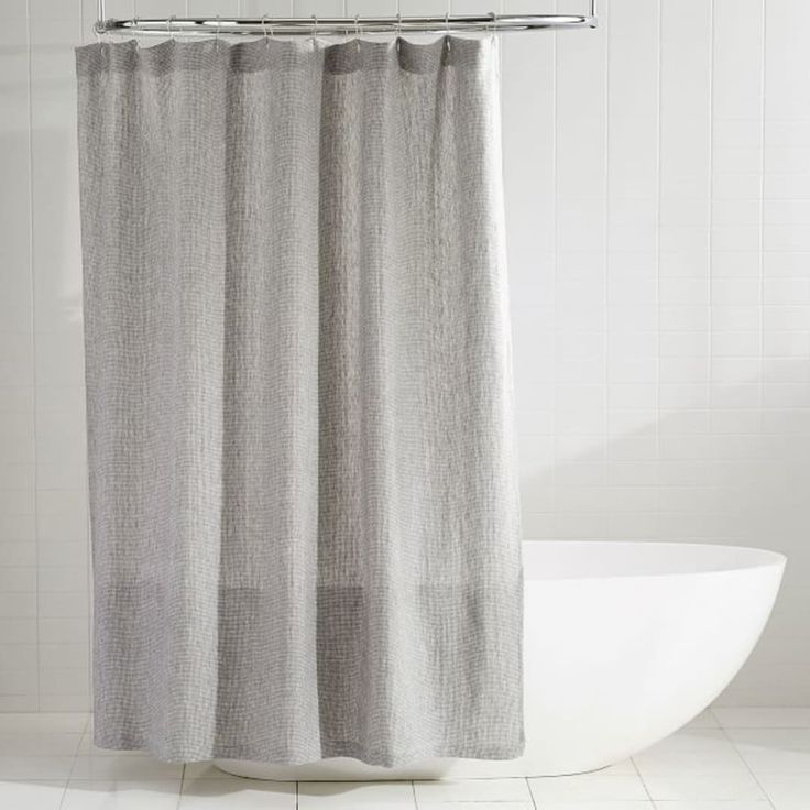 a white bath tub sitting next to a shower curtain