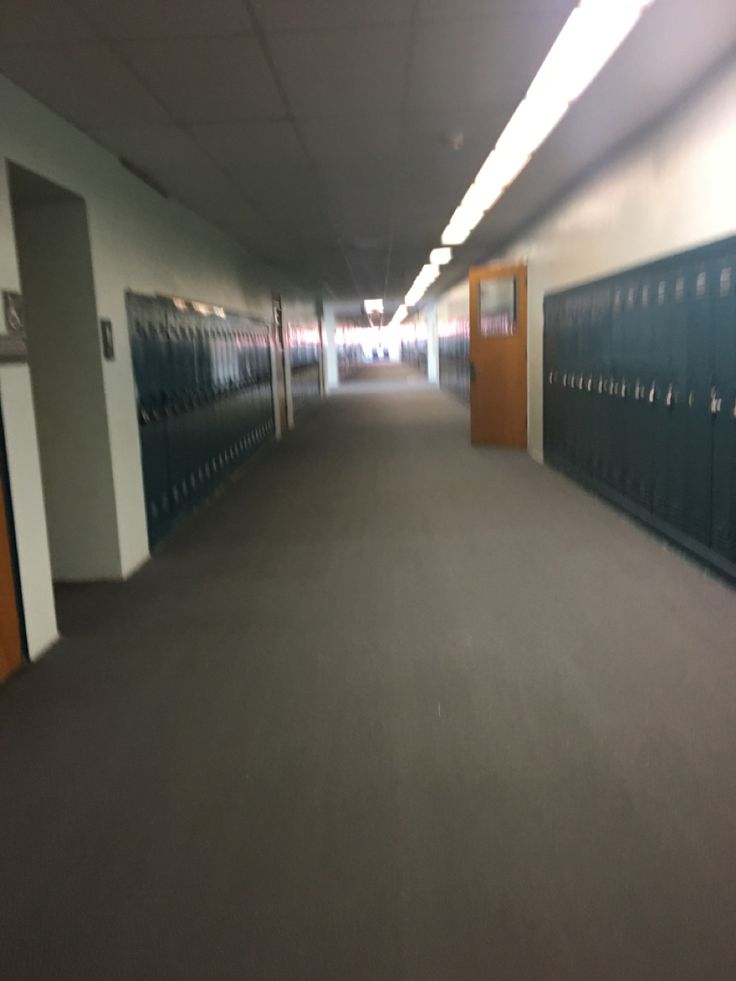 an empty hallway with several lockers on the walls