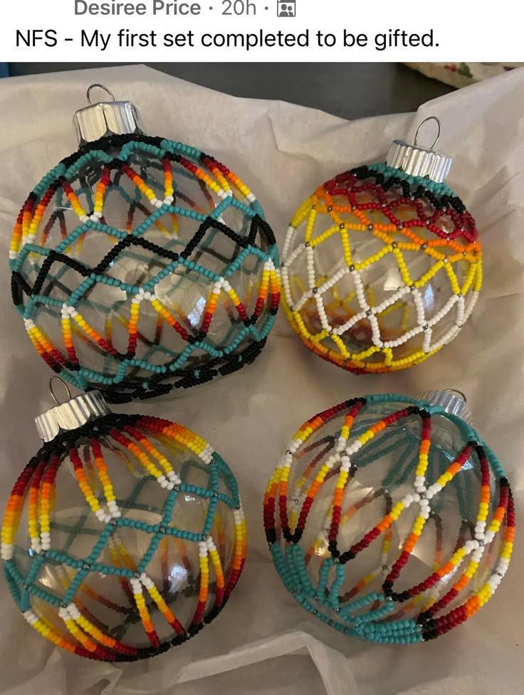 four glass christmas ornaments are sitting on a sheet of white paper with the words, nfs - my first set completed to be glited