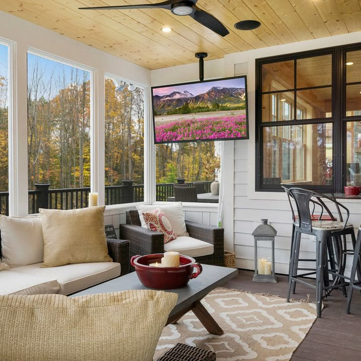 a living room filled with furniture and a flat screen tv mounted to the side of a wall