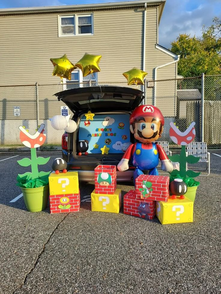 an inflatable mario birthday decoration with balloons and decorations on the back of it