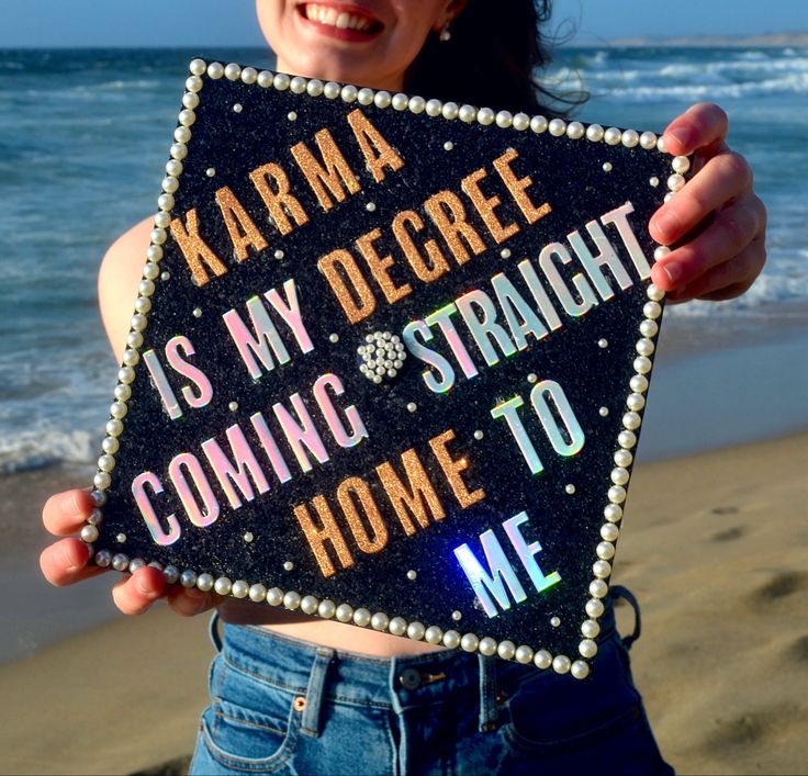 a woman holding up a sign that says karma is my degree coming straight home to me