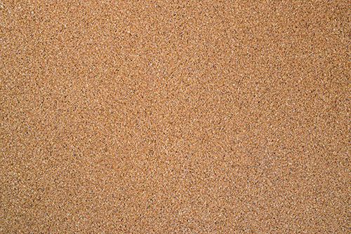 an orange and white cat laying on top of a sandy beach