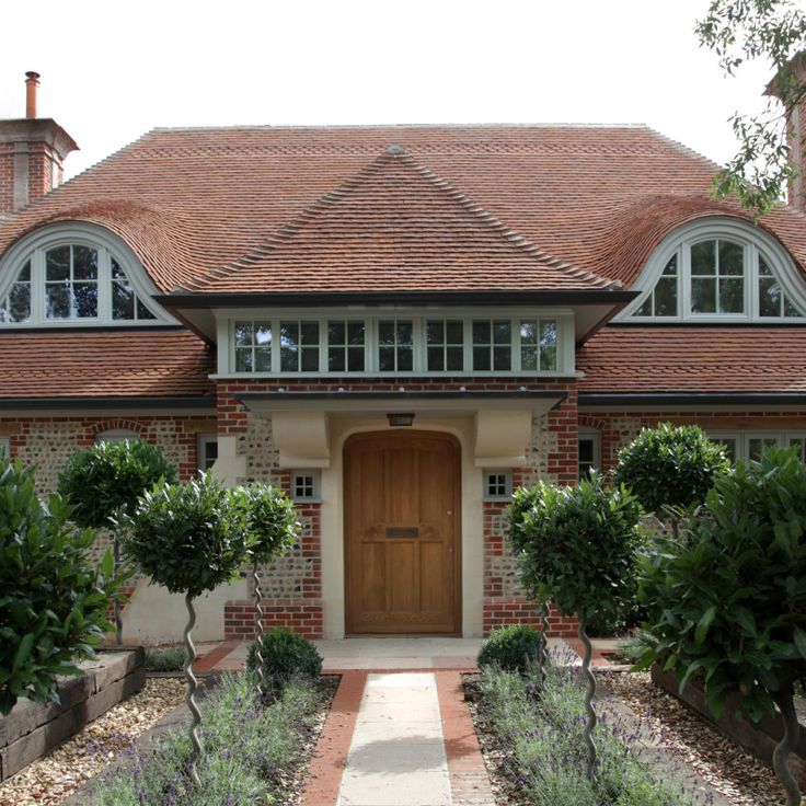 a brick house with two large windows and a wooden door