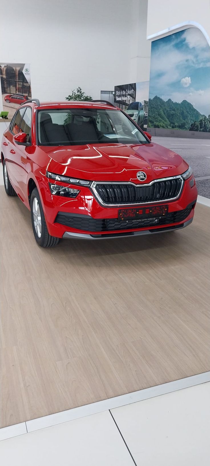 a red car is parked in a showroom