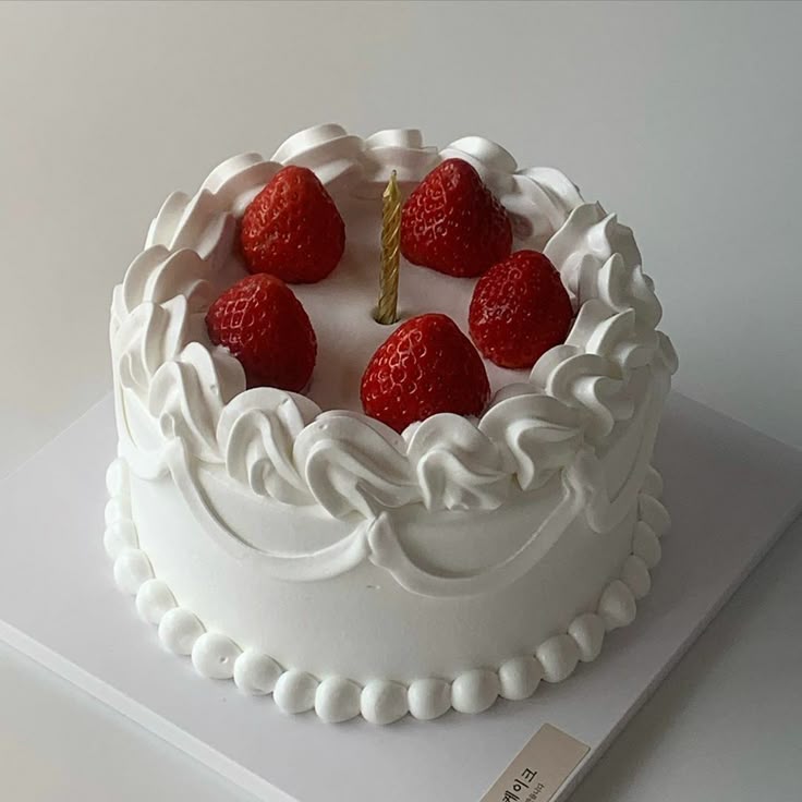 a cake with white frosting and strawberries on top