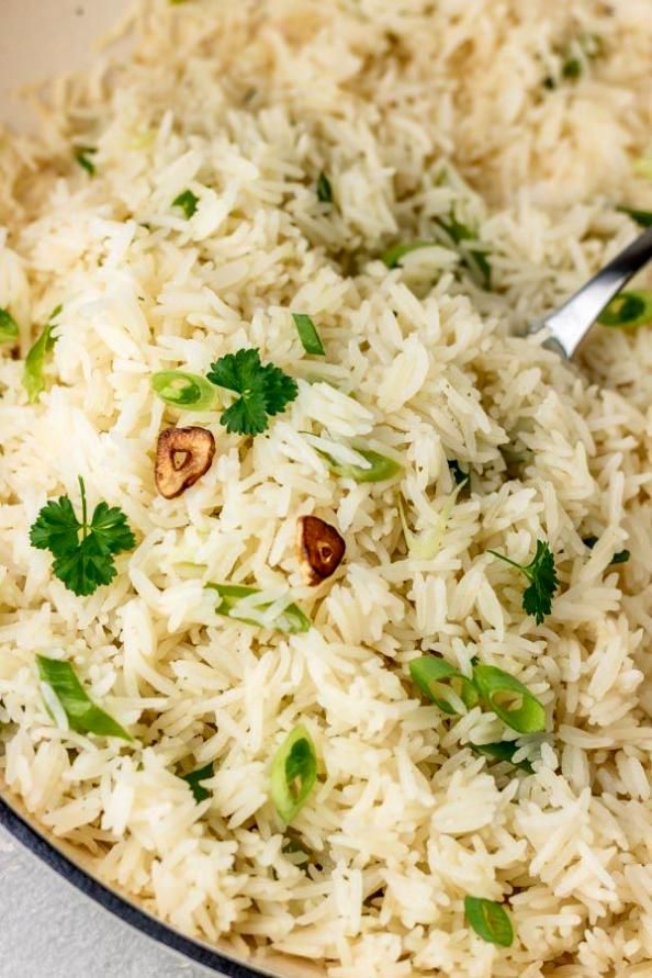 a bowl filled with white rice and garnished with parsley