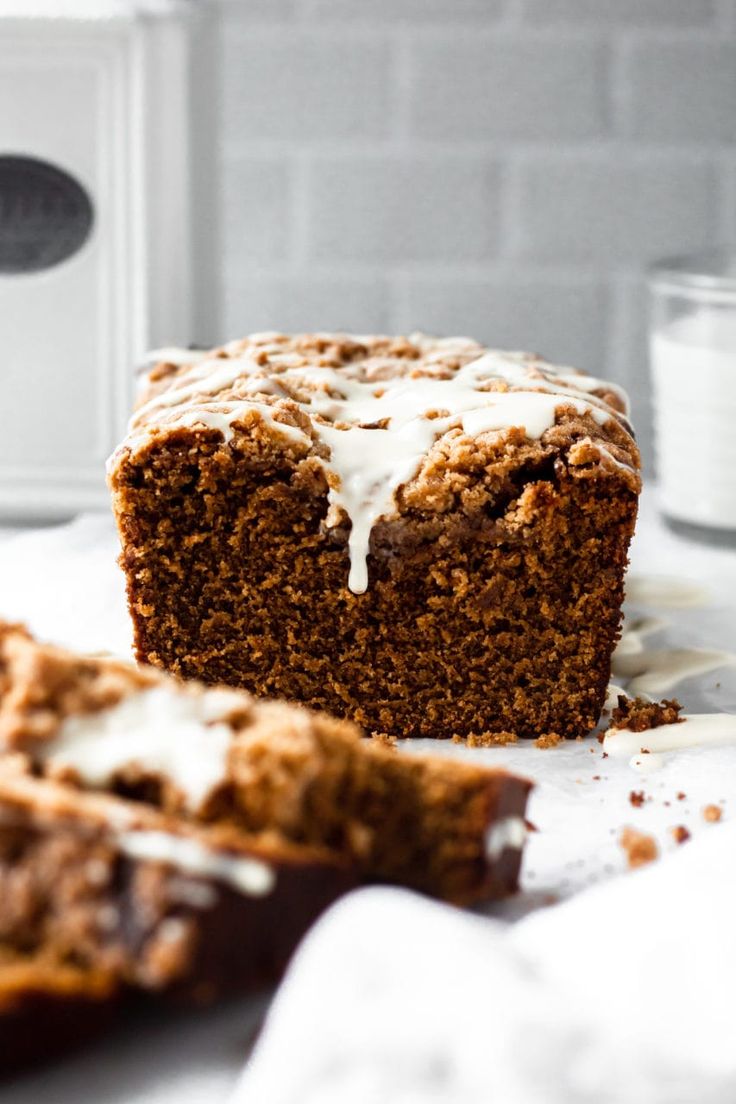 a loaf of cake sitting on top of a table next to a glass of milk